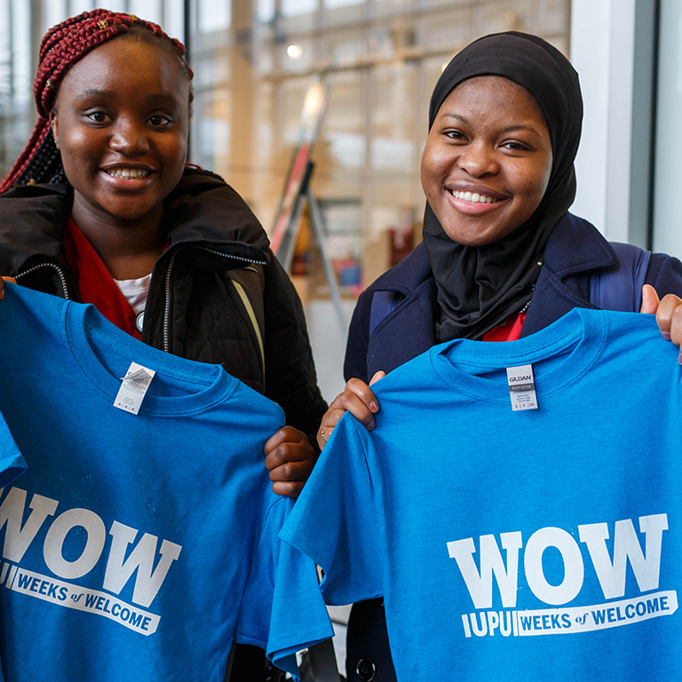 Two students posing with their Weeks of Welcome shirts.